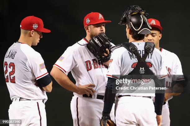 Relief pitcher Joey Krehbiel of the Arizona Diamondbacks talks with catcher John Ryan Murphy before making his MLB debut in the seventh inning of the...