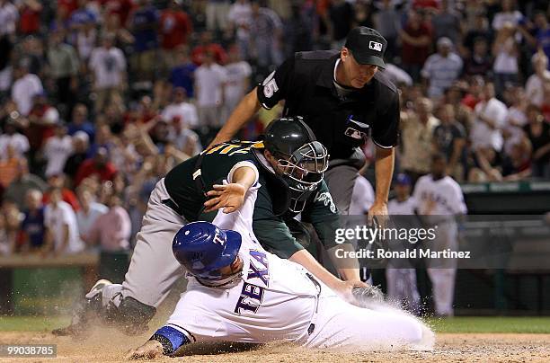 Catcher Landon Powell of the Oakland Athletics makes the out against Andres Blanco of the Texas Rangers in the 12th inning on May 11, 2010 at Rangers...
