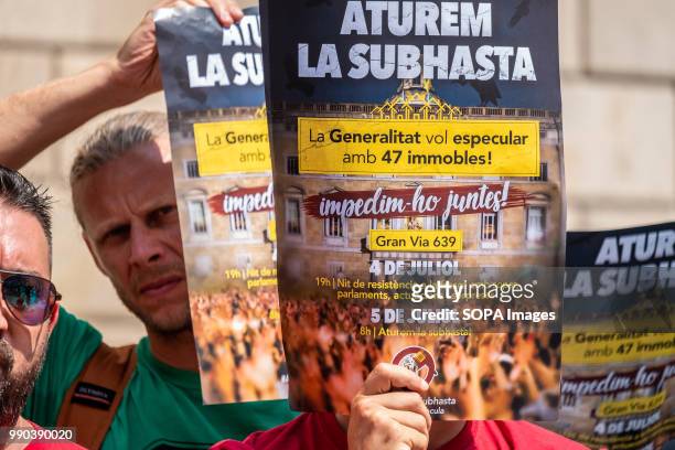 Poster of the call of the 5th of July is seen in the foreground. The Generalitat of Catalonia intends to auction this week 47 properties from...