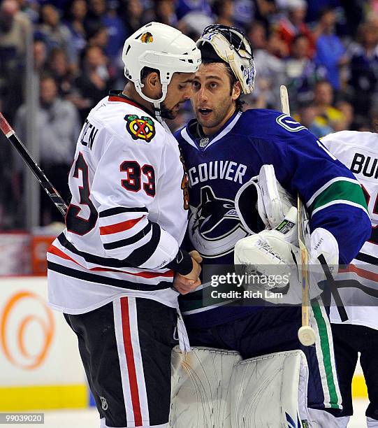 Goalie Roberto Luongo of the Vancouver Canucks congratulates Dustin Byfuglien of the Chicago Blackhawks while shaking hands after the Blackhawks...