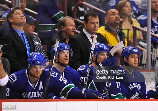 Henrik Sedin, Mikael Samuelsson, Daniel Sedin and Kyle Wellwood of the Vancouver Canucks along with coaches Ryan Walter and Alain Vigneault sit on...