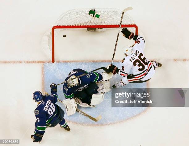 Pavol Demitra and Roberto Luongo of the Vancouver Canucks look on as Dave Bolland of the Chicago Blackhawks celebrates his goal in Game 6 of the...