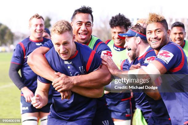 Reece Hodge of the Rebels is tackled by Vaauli Fa'amausili and teammates during a Melbourne Rebels Super Rugby training session at Gosch's Paddock on...