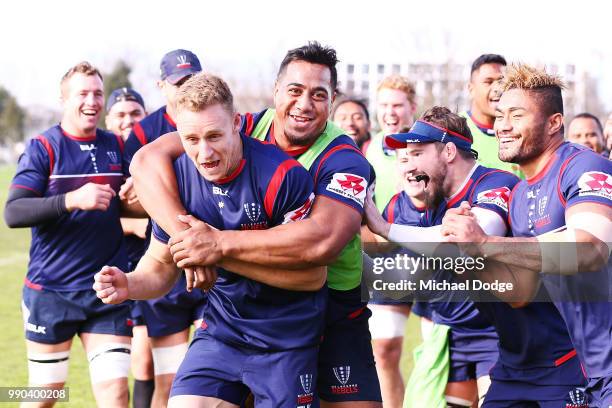 Reece Hodge of the Rebels is tackled by Vaauli Fa'amausili and teammates during a Melbourne Rebels Super Rugby training session at Gosch's Paddock on...