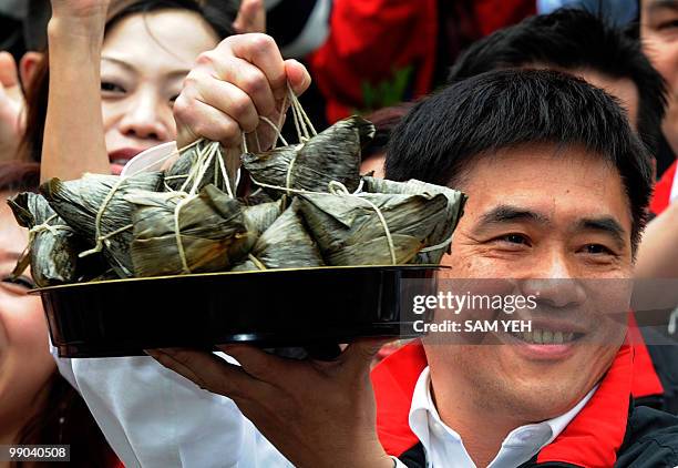 Taipei mayor Hau Lung-bin displayed a string of sticky rice dumplings "zong zi" given to him by his supporters for good luck at the Boan temple in...