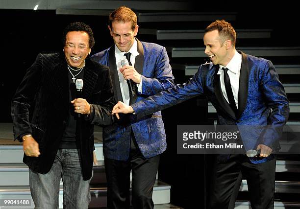 Motown legend Smokey Robinson and singers Toby Allen and Andrew Tierney of the Australian vocal group Human Nature react during a performance after...