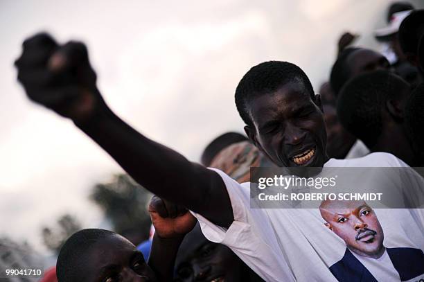 Burundian man wearing a t-shirt showing the image of Burundian President who is running for reelection, Pierre Nkurunziza, clenches his fist as he...