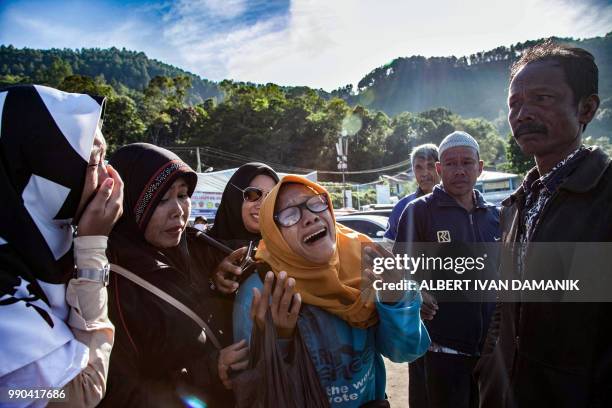 Family members of missing victims of a capsized ferry mourn during a mass memorial service at Lake Toba in North Sumatra on July 3, 2018. - The...