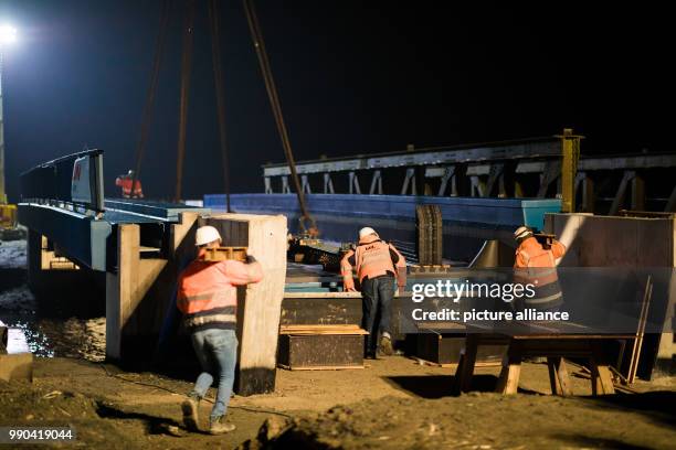 Deutsche Bahn workers secure a 30-metre-long railway bridge weighing 150 tons, which has been set down over the "Ellenserdammer Tief" watercourse by...