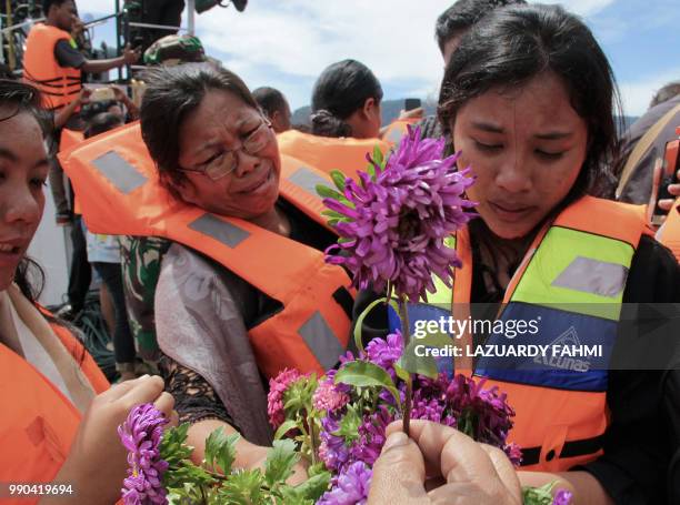 Family members of missing victims of a capsized ferry mourn during a mass memorial service at Lake Toba in North Sumatra on July 3, 2018. - The...
