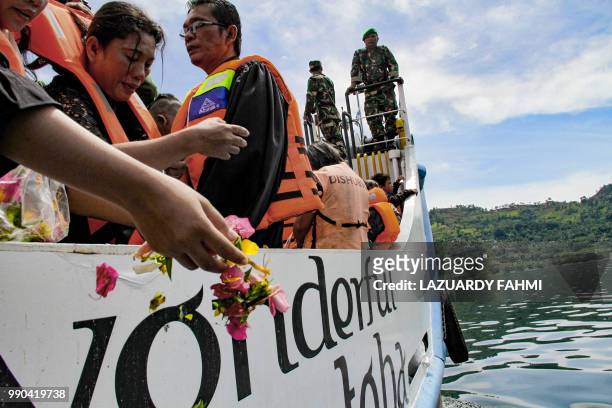 Family members of missing victims of a capsized ferry mourn during a mass memorial service at Lake Toba in North Sumatra on July 3, 2018. The...