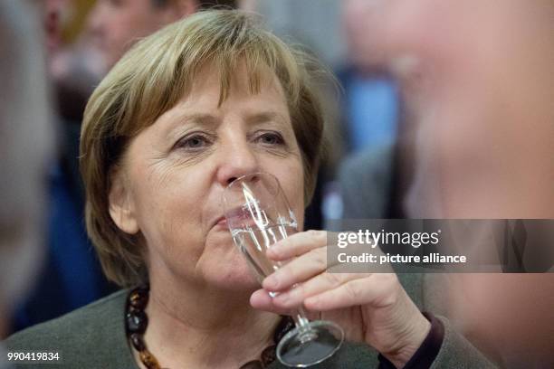 German Chancellor Angela Merkel drinks during the New Year's Reception of the state counsil of the district Vorpommern-Ruegen in...