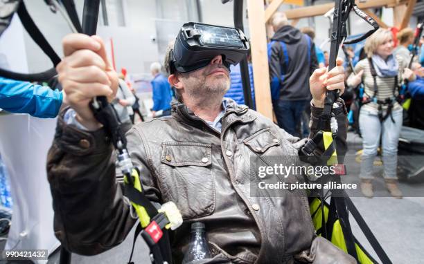 Visitor has a go at a VR paragliding simulator at the Caravan, Motor and Tourism trade fair in Stuttgart, Germany, 13 January 2018. About 2000...