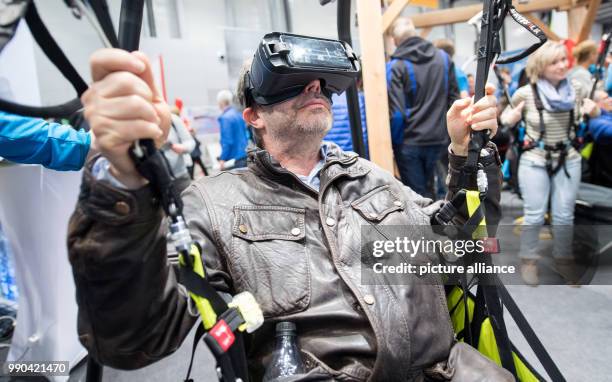 Visitor has a go at a VR paragliding simulator at the Caravan, Motor and Tourism trade fair in Stuttgart, Germany, 13 January 2018. About 2000...