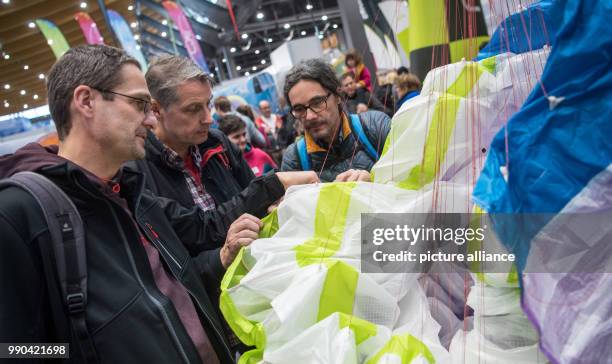 Visitors inspect a paraglider sold by the company Nova at the Caravan, Motor and Tourism trade fair in Stuttgart, Germany, 13 January 2018. About...
