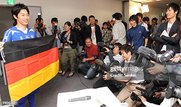 Cerezo Osaka Football player Shinji Kagawa poses for photographs with the German national flag during a press conference announcing his transfer to...