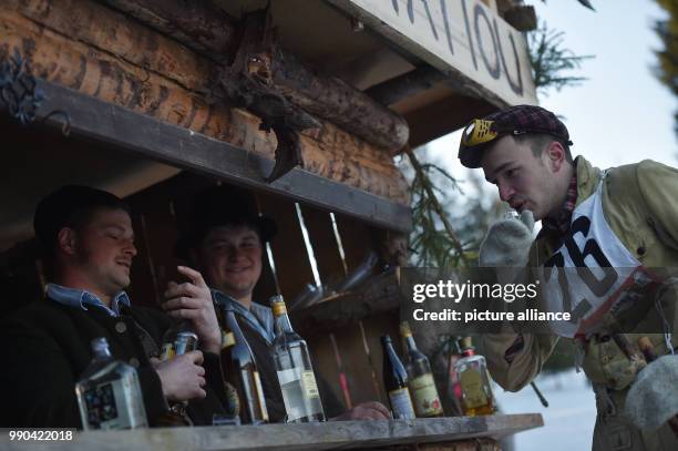 Equipped with wooden skis and wearing traditional clothing, a skier drinks schnapps at a nostalgic ski race in Kruen, Germany, 13 January 2018....