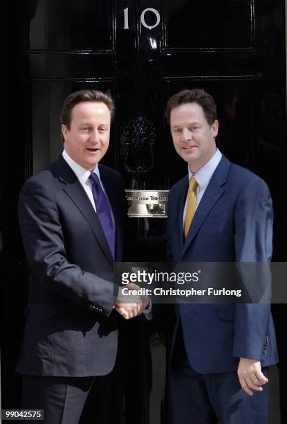 British Prime Minister David Cameron welcomes Deputy Prime Minister Nick Clegg to Downing Street for their first day of coalition government on May...