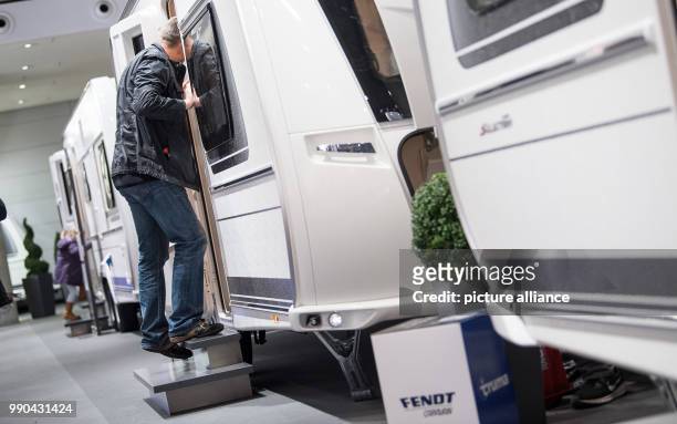Man looks inside a caravan at the travel fair 'Caravan Motor Touristik' in Stuttgart, Germany, 13 January 2018. In the course of the CMT the annual...