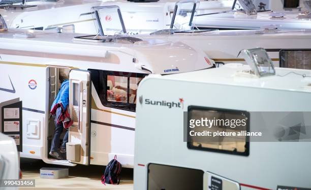 Man takes a look at a caravan of the company Eura Mobil at the travel fair 'Caravan Motor Touristik' in Stuttgart, Germany, 13 January 2018. In the...
