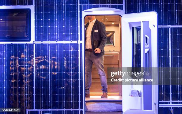 An exhibitor stands in a caravan with solar panels of the company 'Dethleffs' - the so called e.home - at the travel fair 'Caravan Motor Touristik'...