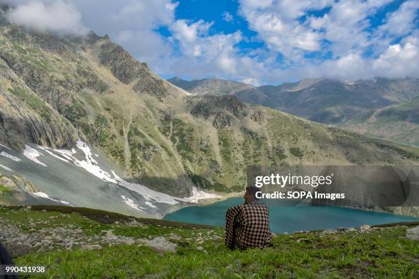 Kashmiri boy seen watching the view of Gangabal lake located in foothills of Mount Harmukh. The Gangabal Lake also called Gangabal Lake, is a lake...