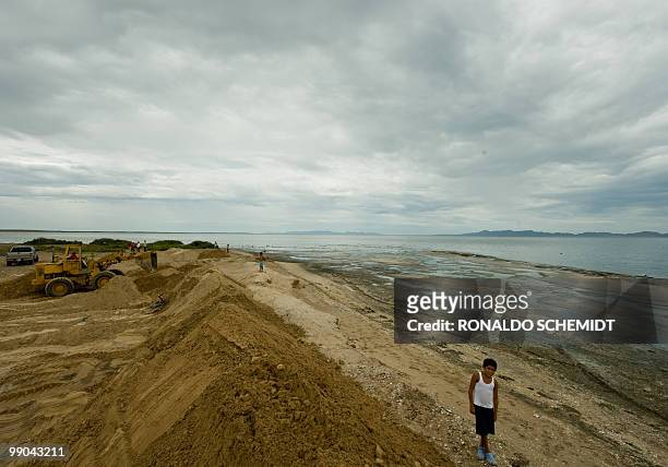 Mexican worker on an earth mover erects a sand wall face to the sea before the arrival of Hurricane Jimena, on a beach in Puerto San Carlos, Baja...