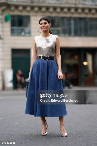 Giovanna Battaglia wears a silver sleeveless top, a blue denim skirt, a belt, outside Schiaparelli, during Paris Fashion Week Haute Couture Fall...