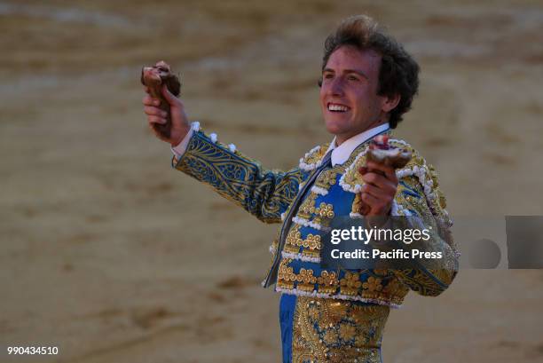 Spanish bullfighter Roman Collado holds two ears after he finished the bull during a bullfight at the 'La Chata' bullring in Soria, north of Spain.