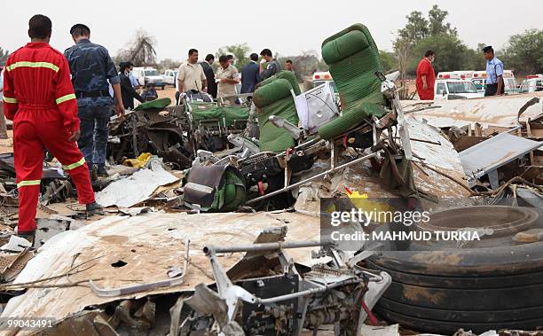 Libyan security forces and rescue teams inspect the debris of an Afriqiyah Airways passenger plane which crashed during landing at Tripoli airport on...