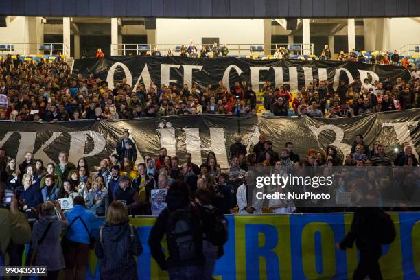 People hold banners, with the words &quot;Oleg Sentsov, Ukraine with you!&quot; during a flash mob at the NSC Olympiyskiy Stadium in Kyiv on July 2...