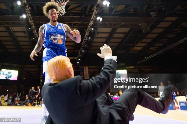 Julian Gamble high fives a man wearing a Donald Trump costume after jumping over him at the Allstar Day of the Basketball Bundesliga in Goettingen,...