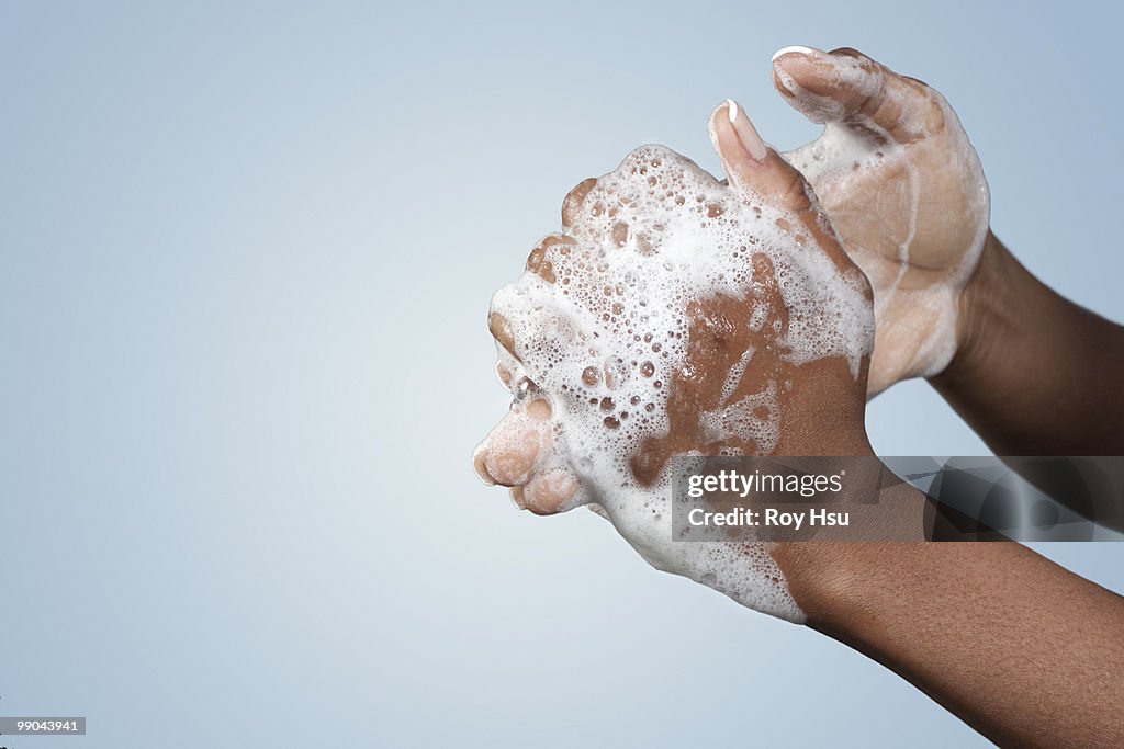 Black woman washing hands with soap