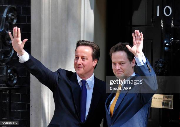 Britain's new Prime Minister David Cameron and new Deputy Prime Minister Nick Clegg, wave as they pose for pictures outside 10 Downing Street in...