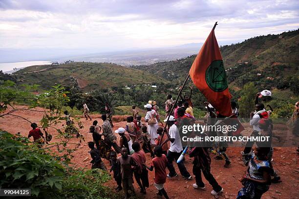 Group of followers of the main opposition party shout slogans as they make their way down a country road in the mountains surrounding Burundi's...