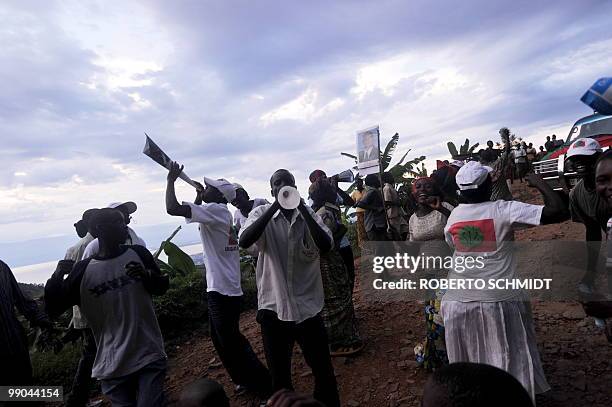 Group of followers of the main opposition party shout slogans as they make their way down a country road in the mountains surrounding Burundi's...