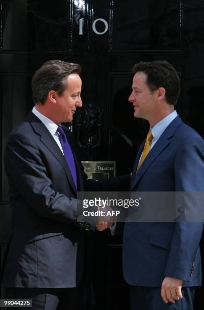 Britain's new Prime Minister David Cameron and new Deputy Prime Minister Nick Clegg, shake hands as they pose for pictures outside 10 Downing Street...