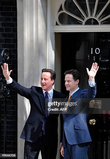 Britain's new Prime Minister David Cameron and new Deputy Prime Minister Nick Clegg, wave as they pose for pictures on the steps of 10 Downing Street...