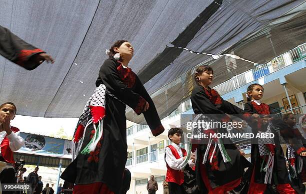 Palestinian school children perform a dance during the opening of a school in Beit Lahia, northern Gaza Strip, which was hit by Israeli fire during...