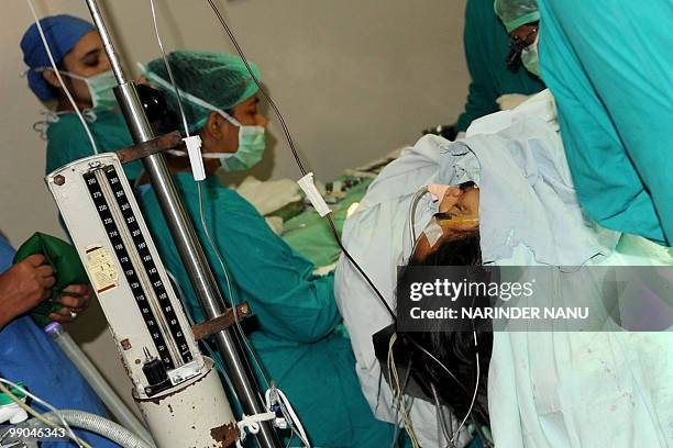 Injured Indian patient Amarpreet Singh is treatedby medical staff in an operating room at Amandeep Hospital in Amritsar on May 12, 2010. In a case of...
