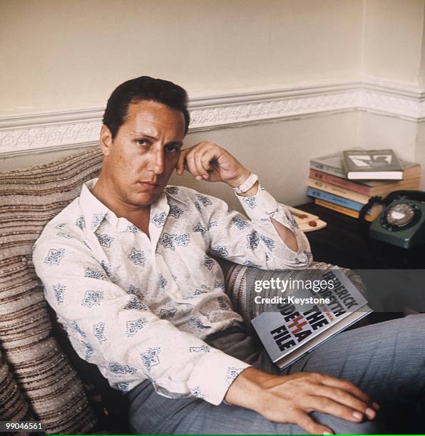 Frederick Forsyth, author, pictured with a copy of his 1972 novel, The Odessa File, circa 1972.