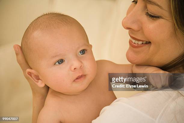 hispanic mother and baby - cream colored background stockfoto's en -beelden