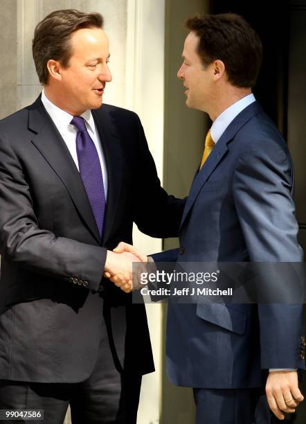 British Prime Minister David Cameron and Deputy Prime Minister Nick Clegg stand at the door to Downing Street on May 12, 2010 in London,...