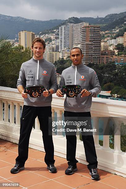 McLaren Mercedes drivers and Formula One World Champions Jenson Button and Lewis Hamilton pose as they present diamond encrusted steering wheels...