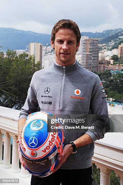 McLaren Mercedes drivers and Formula One World Champion Jenson Button poses as he presents a diamond encrusted steering wheels created for him by...