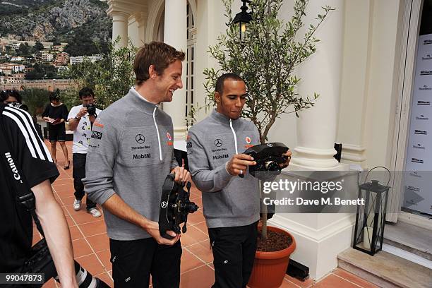 McLaren Mercedes drivers and Formula One World Champions Jenson Button and Lewis Hamilton pose as they present diamond encrusted steering wheels...