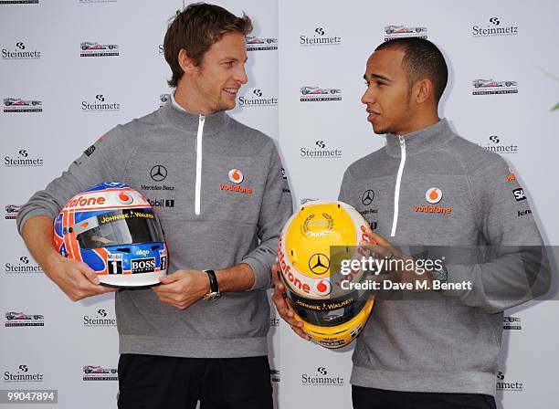 McLaren Mercedes drivers and Formula One World Champions Jenson Button and Lewis Hamilton pose as they present diamond encrusted helmets created for...