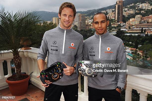 McLaren Mercedes drivers and Formula One World Champions Jenson Button and Lewis Hamilton pose as they present diamond encrusted steering wheels...