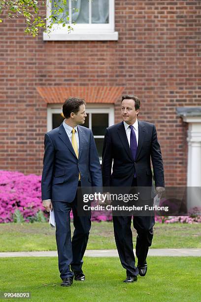 Prime Minister David Cameron and Deputy Prime Minister Nick Clegg arrive for their first joint press conference in the Downing Street garden at...