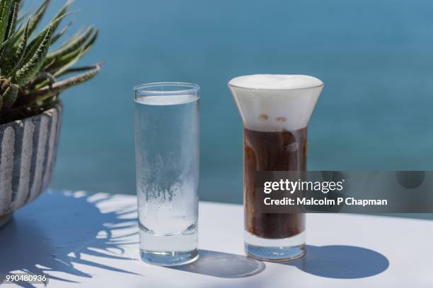 freddo cappuccino - iced cappuccino coffee drink served with water, lesvos, greece - lesbos stockfoto's en -beelden